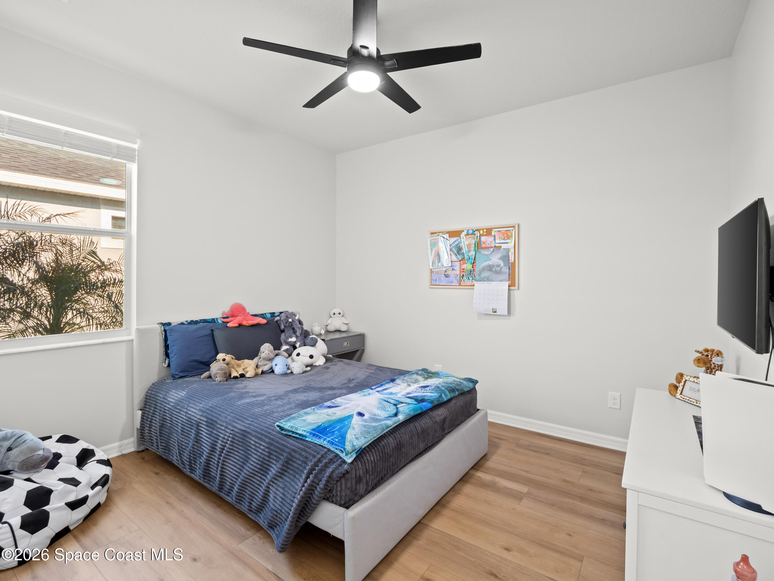 3363 Addison Drive Melbourne, FL 32940 - Photo 24 of 53 a bedroom with a bed and wooden floor