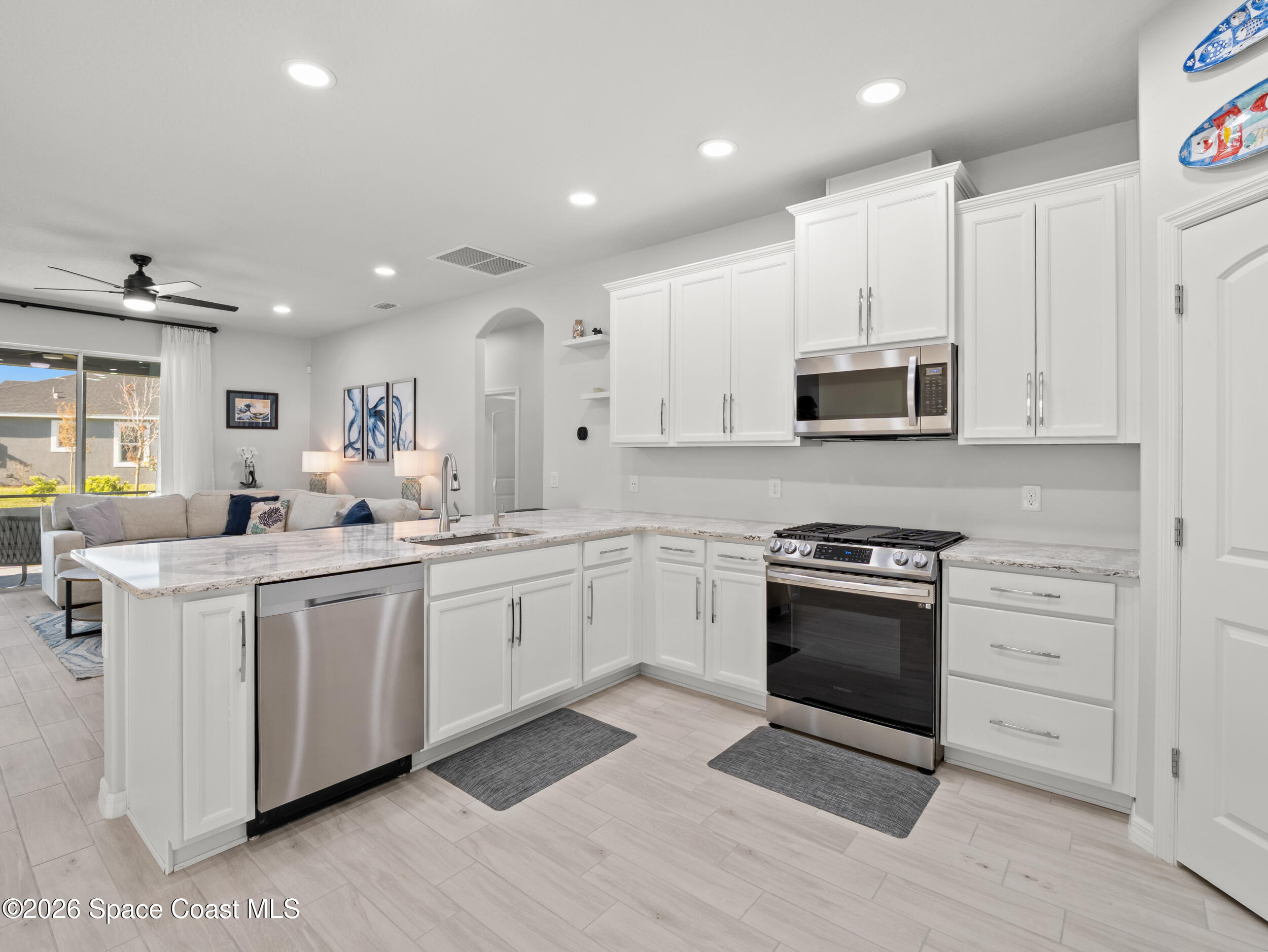 3363 Addison Drive Melbourne, FL 32940 - Photo 4 of 53 a kitchen with stainless steel appliances granite countertop a stove a sink and a microwave
