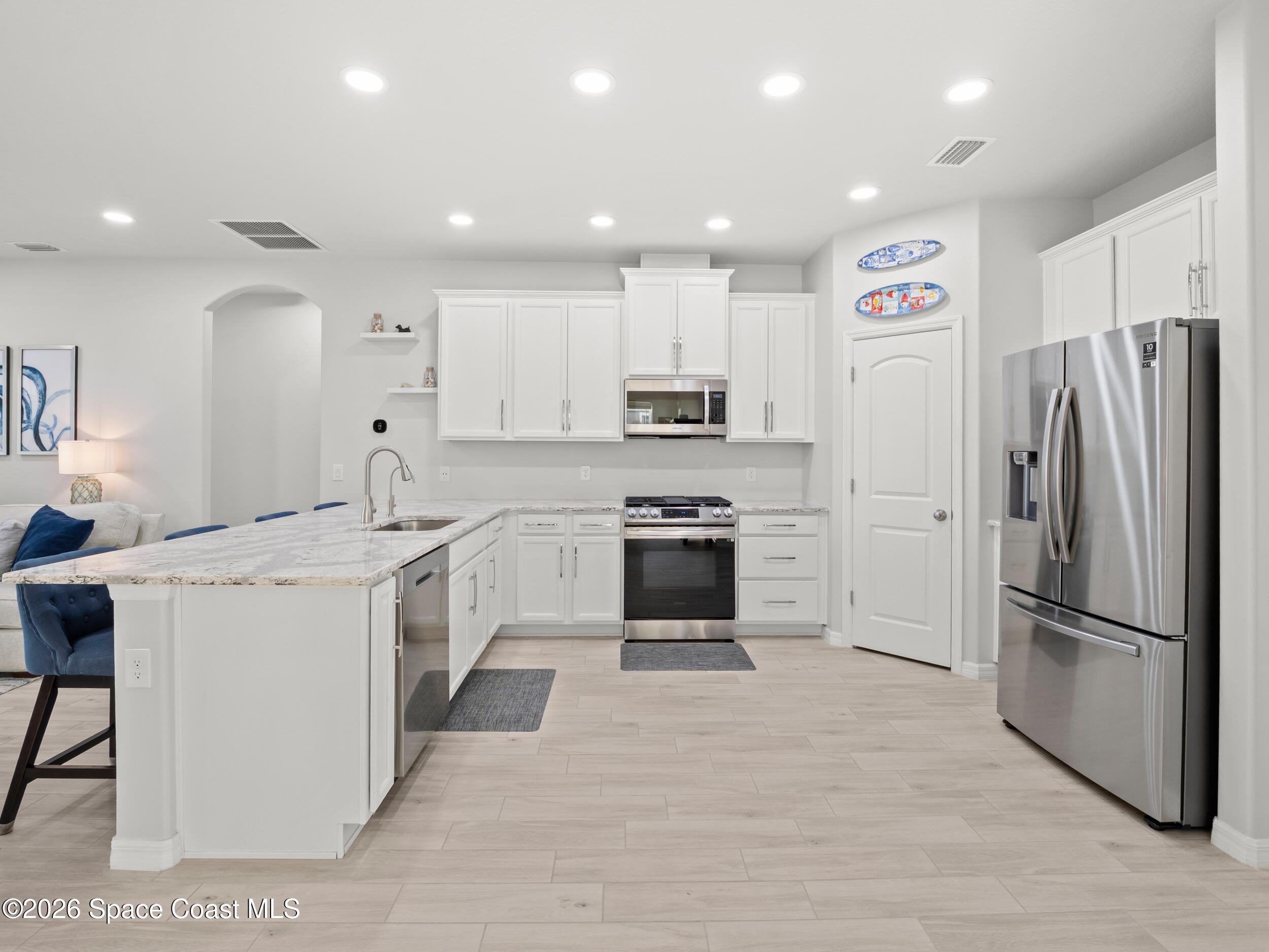 3363 Addison Drive Melbourne, FL 32940 - Photo 5 of 53 a kitchen with stainless steel appliances kitchen island a refrigerator sink and cabinets