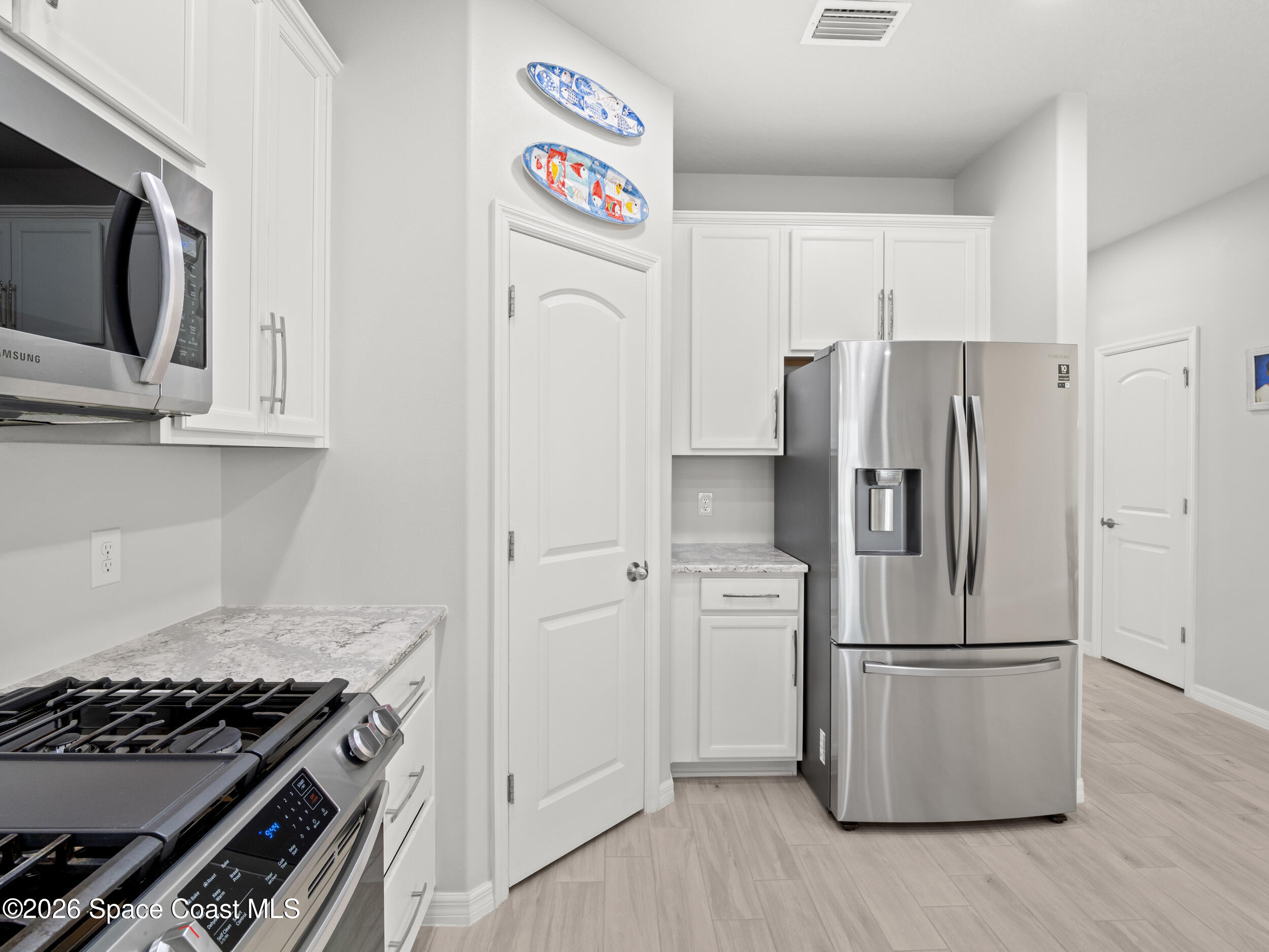 3363 Addison Drive Melbourne, FL 32940 - Photo 6 of 53 a kitchen with stainless steel appliances a refrigerator a stove and cabinets