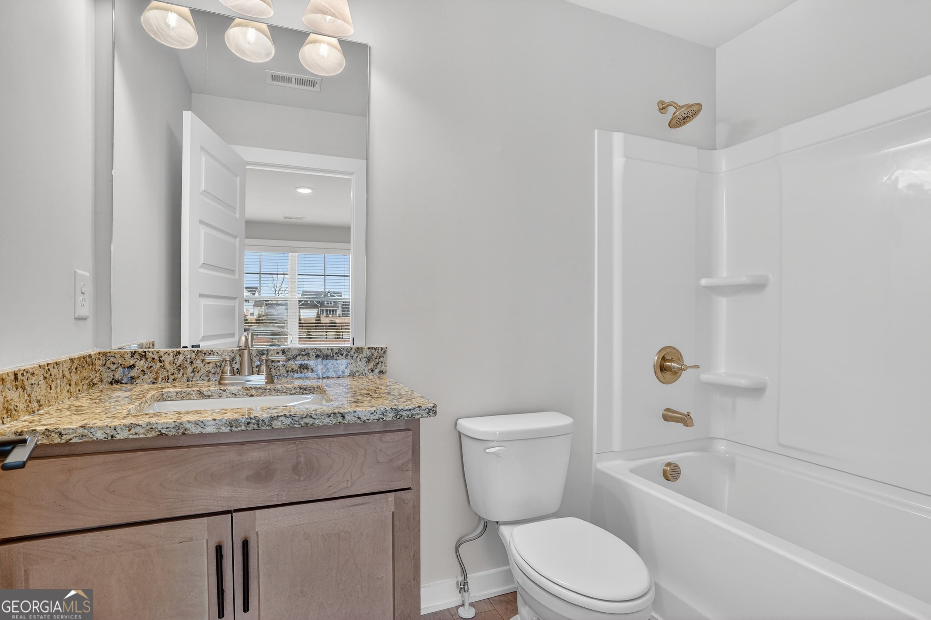 611 Villa Rica Springs Villa Rica, GA 30180 - Photo 22 of 35 a bathroom with a granite countertop sink toilet mirror vanity and bathtub