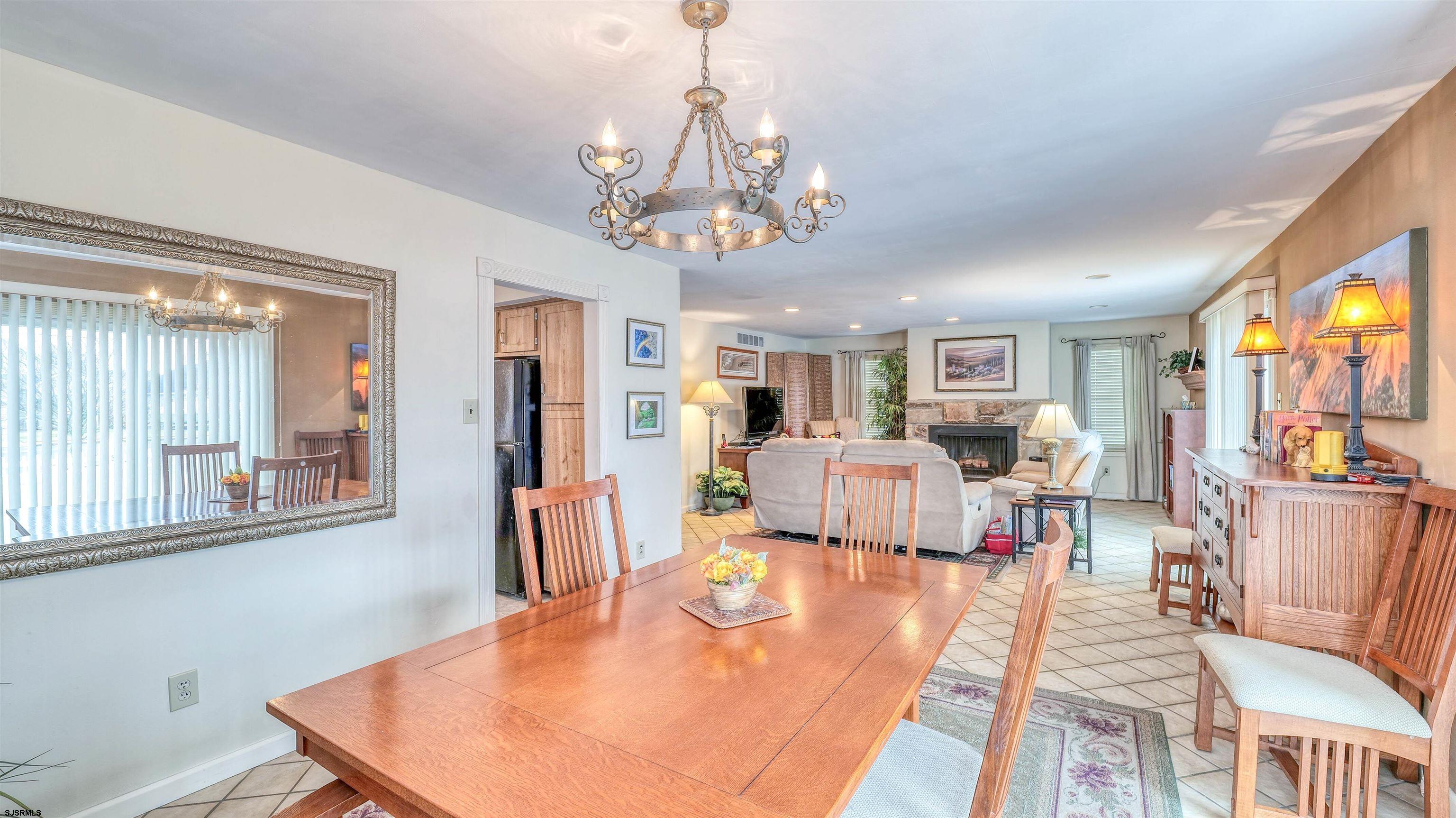 1330 Ouimet Road Brigantine, NJ 08203 - Photo 9 of 43 a view of a dining room with furniture a chandelier and wooden floor