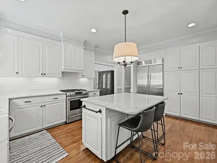 a open kitchen with stainless steel appliances granite countertop a kitchen island a stove and a cabinets