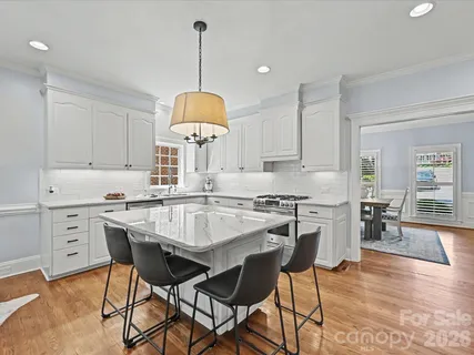 a kitchen with a dining table chairs a sink and cabinets