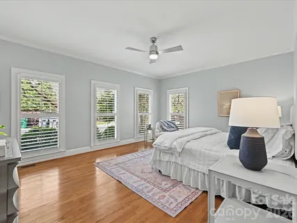 a bedroom with a bed a couch and a window with outer view