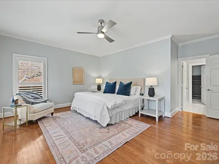 a spacious bedroom with a bed and wooden floor