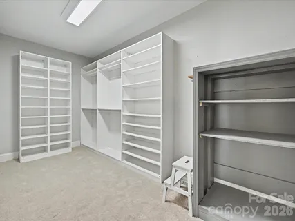 a view of walk in closet with empty racks