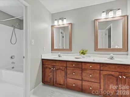 a bathroom with a granite countertop sink two mirror and a
