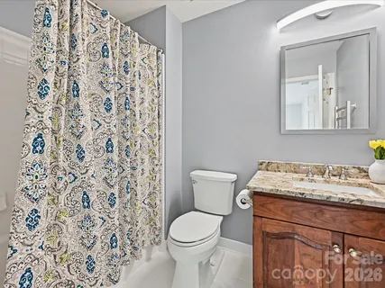 a bathroom with a granite countertop toilet sink and mirror