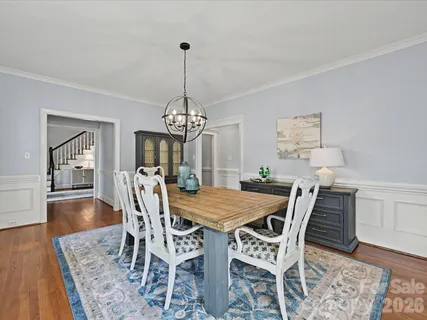 a view of a dining room with furniture a chandelier and wooden floor