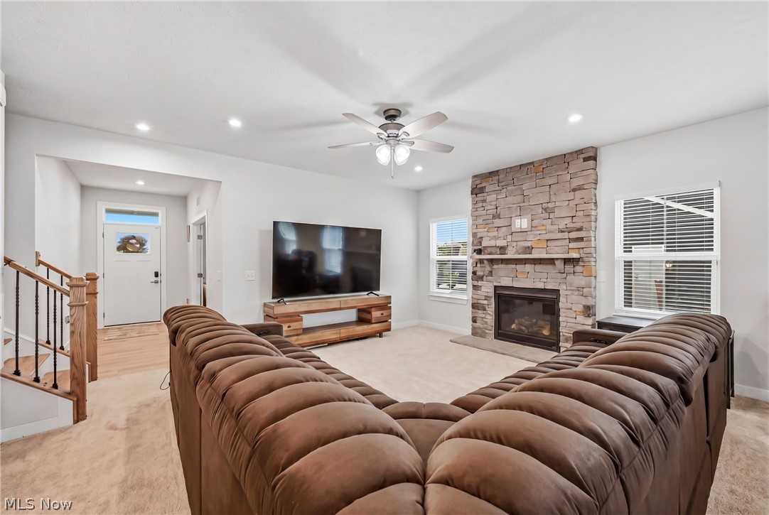5358 Walnut Rdg Lane Sheffield Lake, OH 44054 - Photo 14 of 50 Living area featuring a floor-to-ceiling stone fireplace with a hearth, multiple windows with blinds, recessed lighting, and a ceiling fan