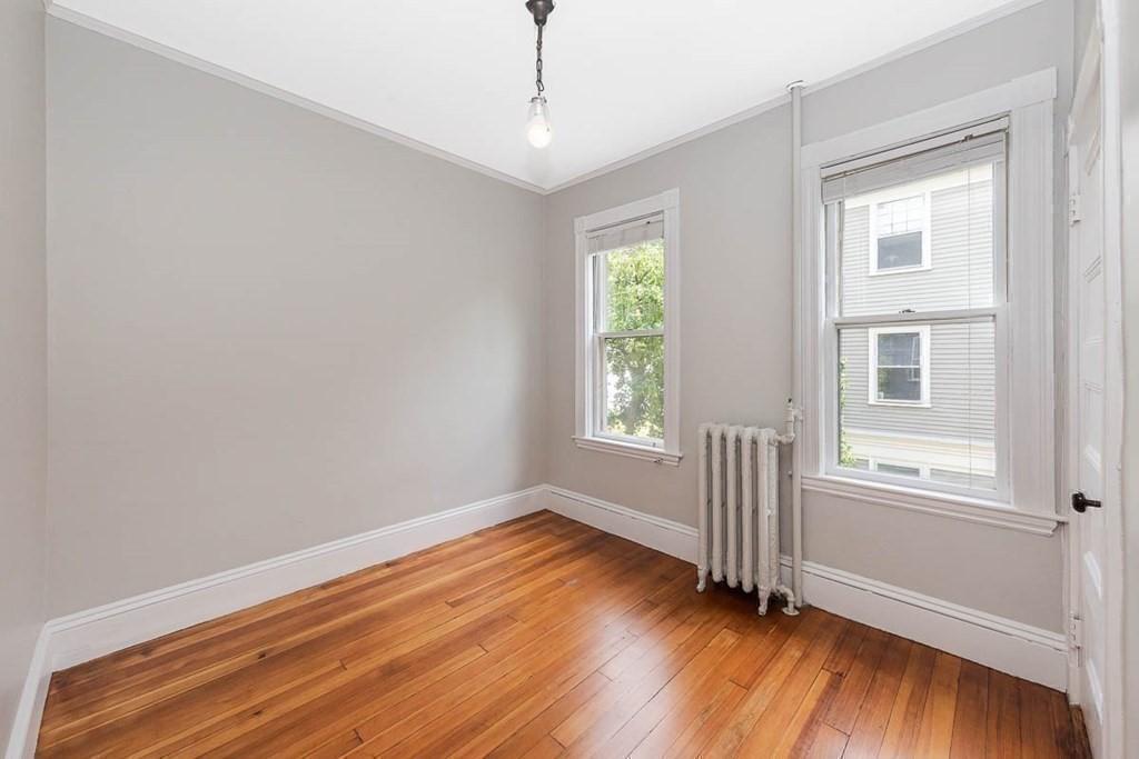 33 Stanton Road, Unit 2 Brookline, MA 02445 - Photo 15 of 19 an empty room with wooden floor and windows