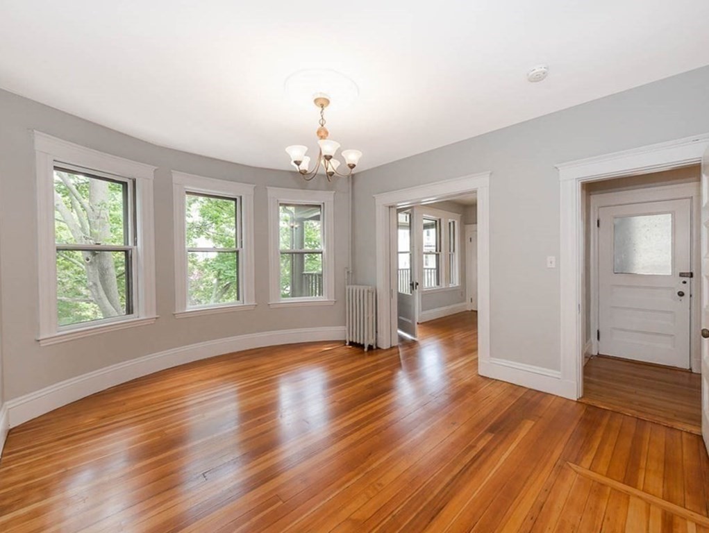 33 Stanton Road, Unit 2 Brookline, MA 02445 - Photo 3 of 19 an empty room with wooden floor and windows