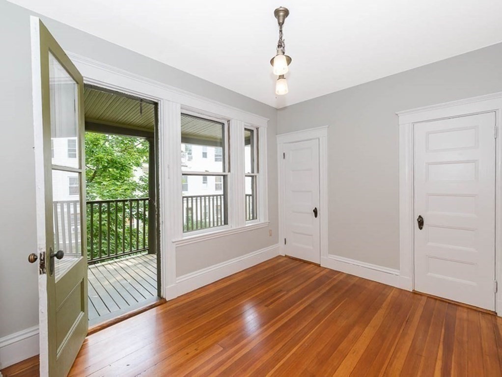 33 Stanton Road, Unit 2 Brookline, MA 02445 - Photo 5 of 19 a view of an empty room with wooden floor and a window