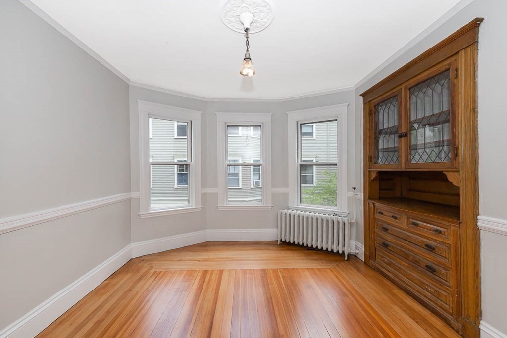 33 Stanton Road, Unit 2 Brookline, MA 02445 - Photo 6 of 19 wooden floor in an empty room with a window