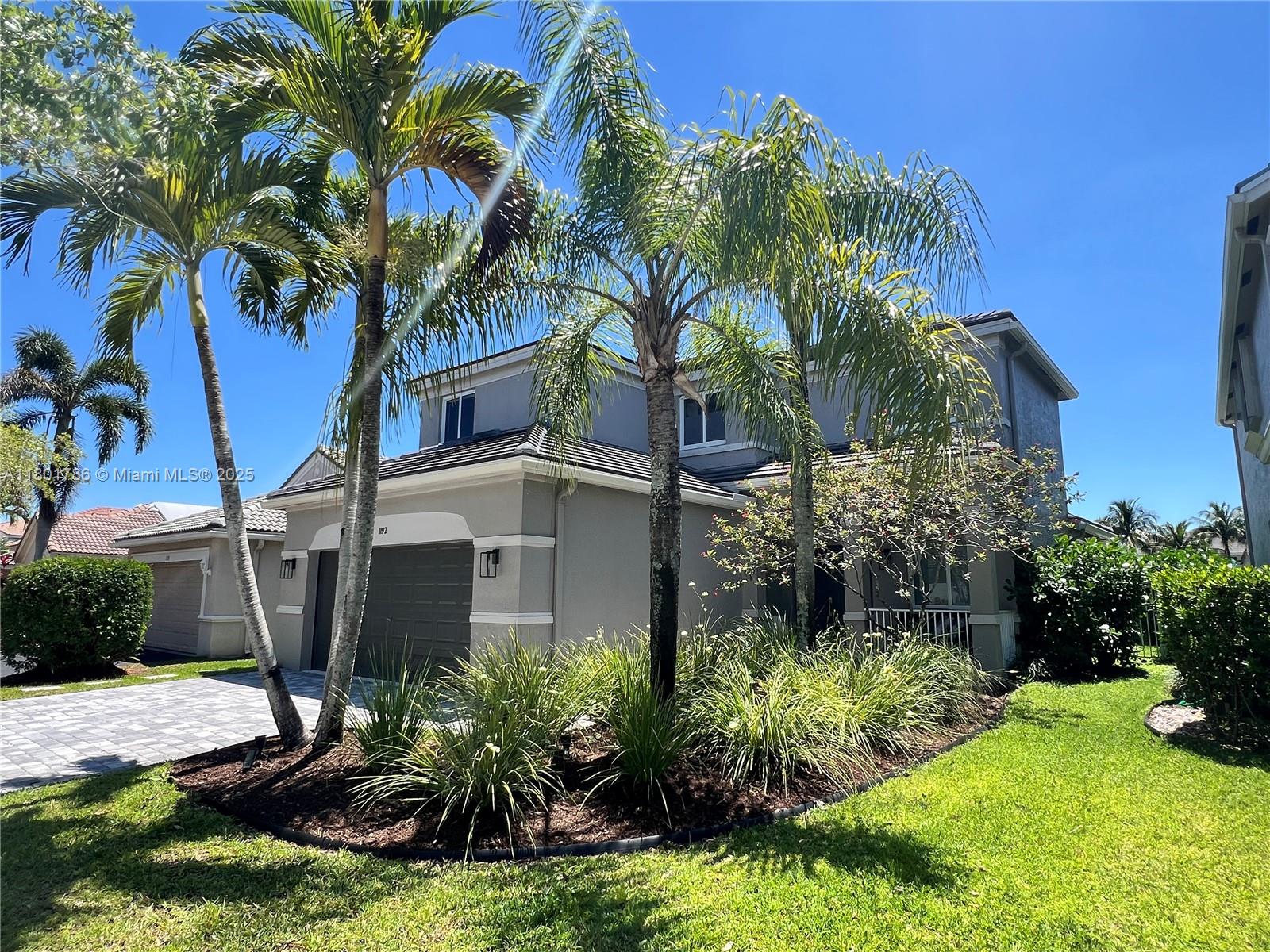 1192 Chinaberry Drive Weston, FL 33327 - Photo 1 of 48 a house that has a tree in front of it
