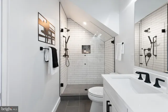 a bathroom with a toilet sink double vanity and mirror