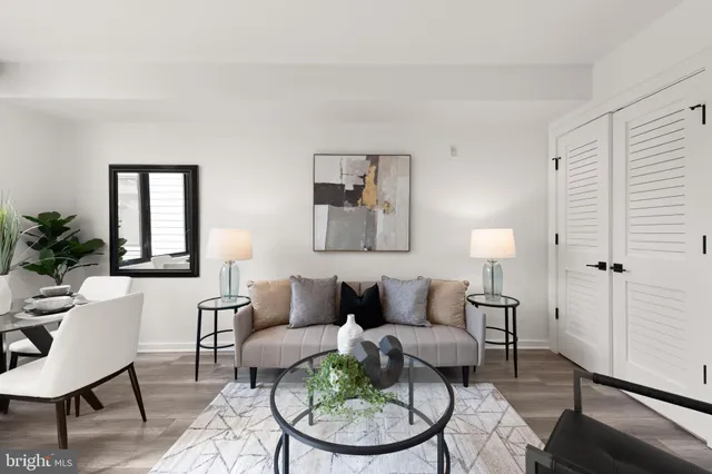 a kitchen with stainless steel appliances a sink a stove a refrigerator and white cabinets with wooden floor