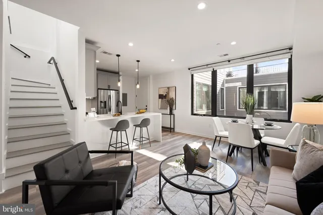 a living room with furniture and a flat screen tv with wooden floor