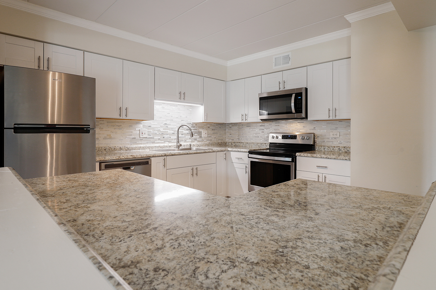 3704 215th Street, Unit 205 Matteson, IL 60443 - Photo 6 of 16 a kitchen with kitchen island a refrigerator sink and white cabinets