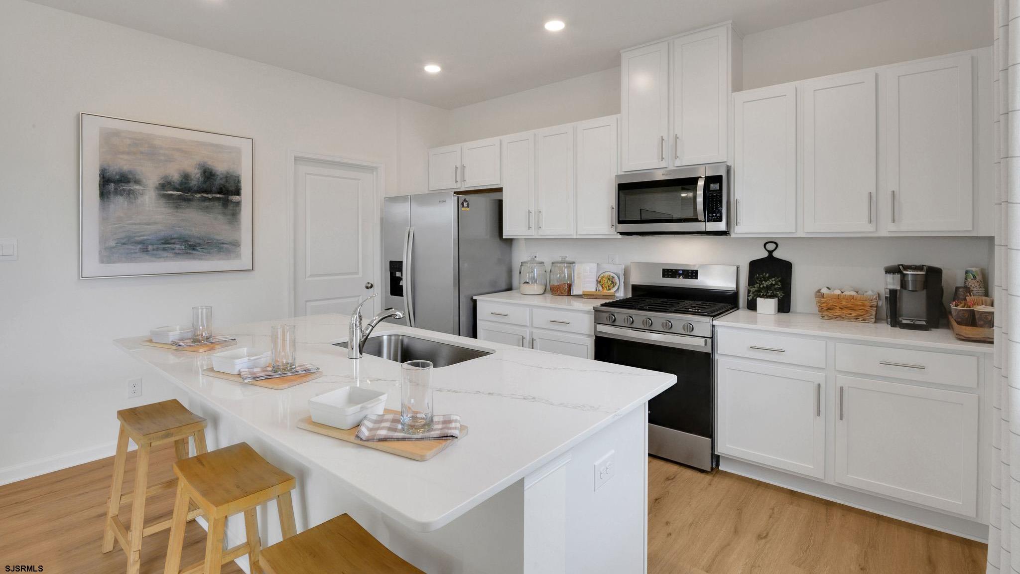224 Daytona Road Egg Harbor Township, NJ 08234 - Photo 17 of 31 a kitchen with stainless steel appliances kitchen island granite countertop a sink a stove a microwave a dining table and chairs