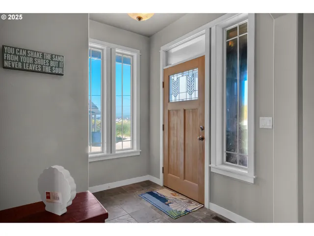 a living room with furniture a flat screen tv and a floor to ceiling window