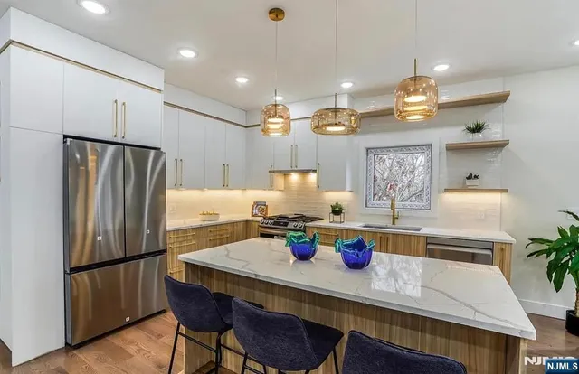 a kitchen with a dining table chairs and refrigerator