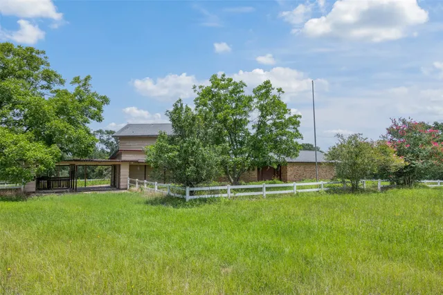 a view of a house with a big yard and potted plants