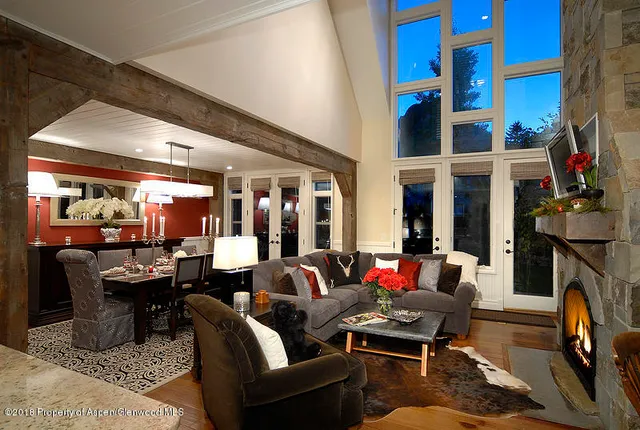 a living room with fireplace furniture and a large window