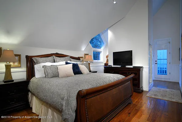 a bedroom with bed and flat screen tv