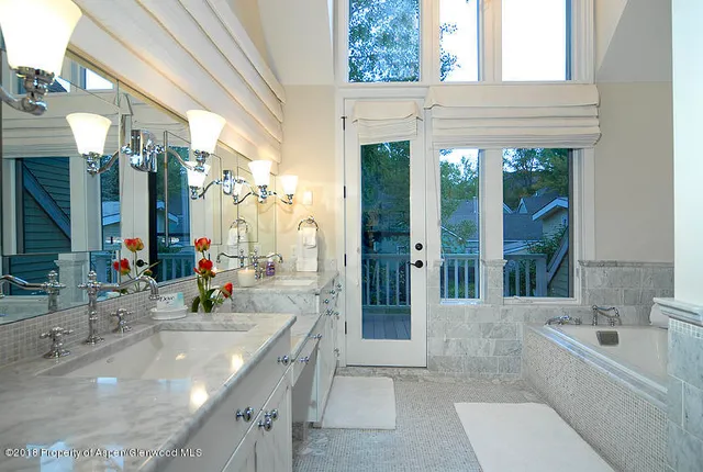 a bathroom with a granite countertop tub sink and mirror