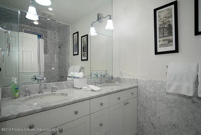 a bathroom with double sink and a mirror