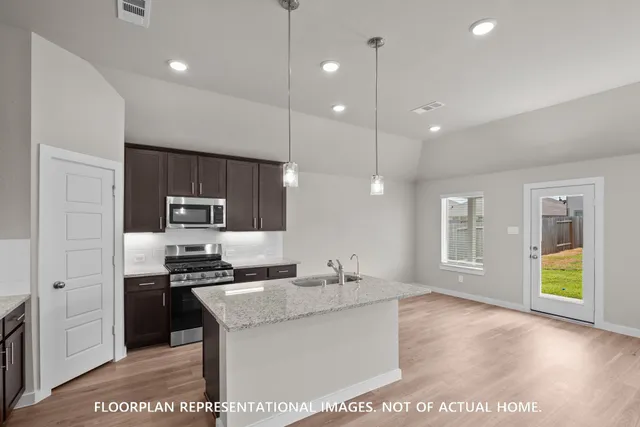 a kitchen with kitchen island a sink stainless steel appliances and cabinets