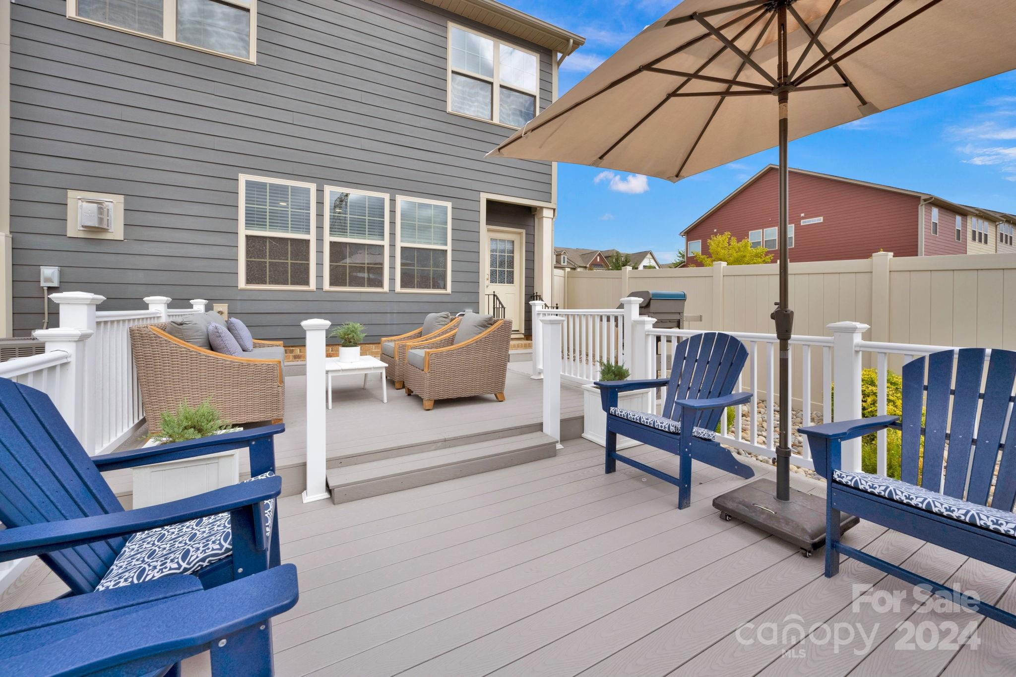 12834 Robert Walker Drive Davidson, NC 28036 - Photo 12 of 27 a roof deck with a table and chairs under an umbrella