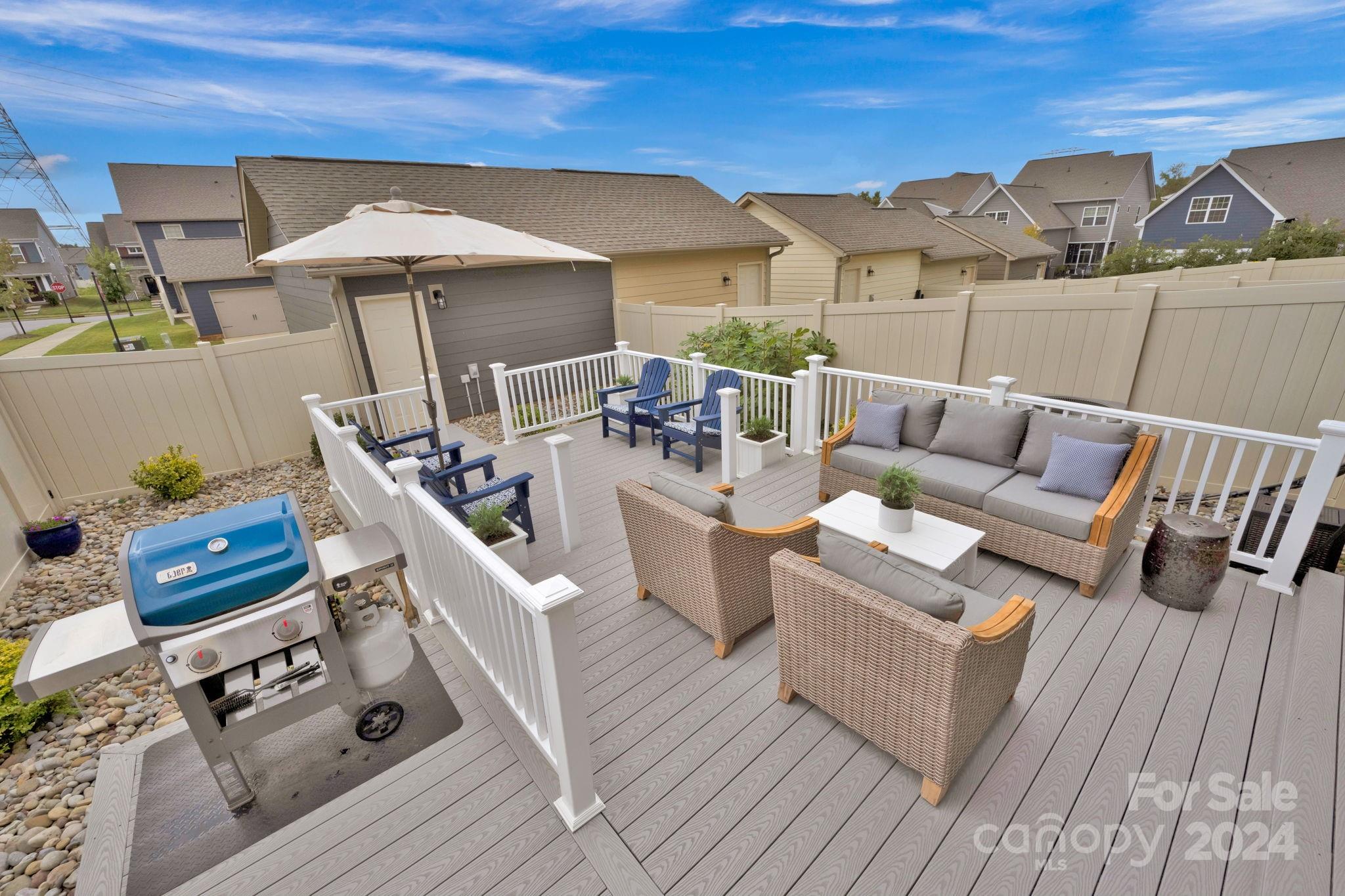 12834 Robert Walker Drive Davidson, NC 28036 - Photo 13 of 27 a view of a patio with couches chairs under an umbrella with wooden floor
