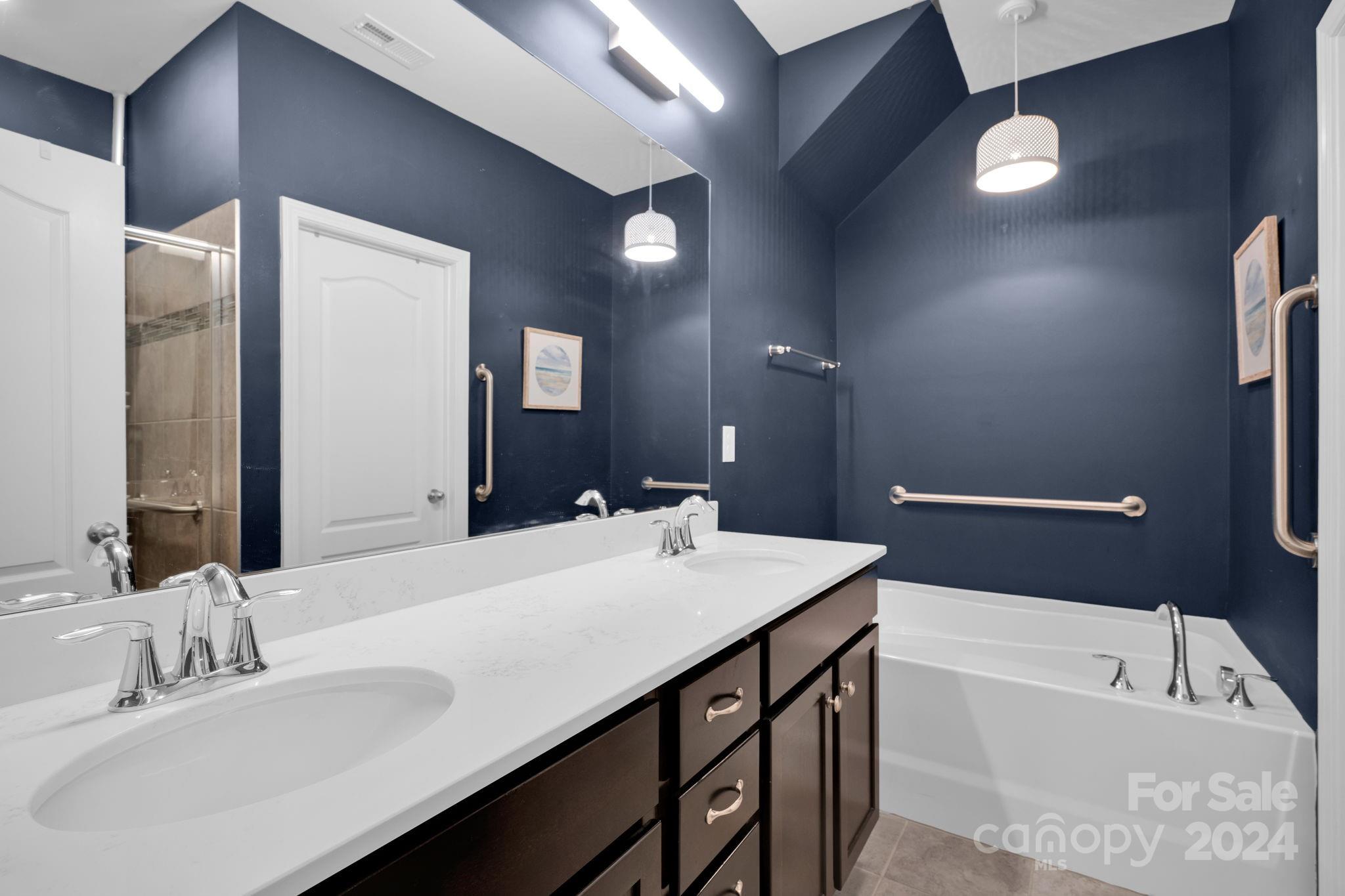 12834 Robert Walker Drive Davidson, NC 28036 - Photo 16 of 27 a bathroom with a sink double vanity granite tub and a mirror