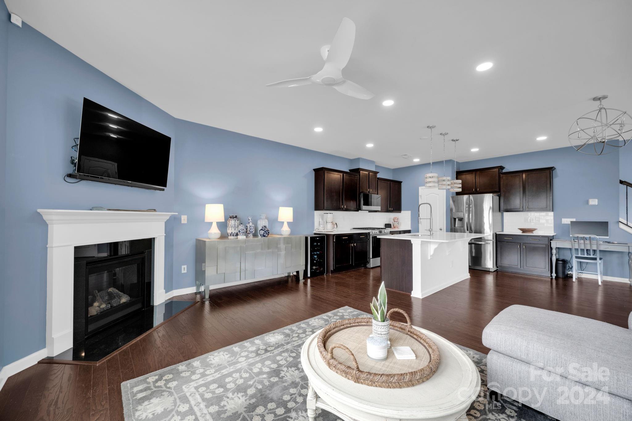 12834 Robert Walker Drive Davidson, NC 28036 - Photo 3 of 27 a living room with furniture a fireplace and a flat screen tv