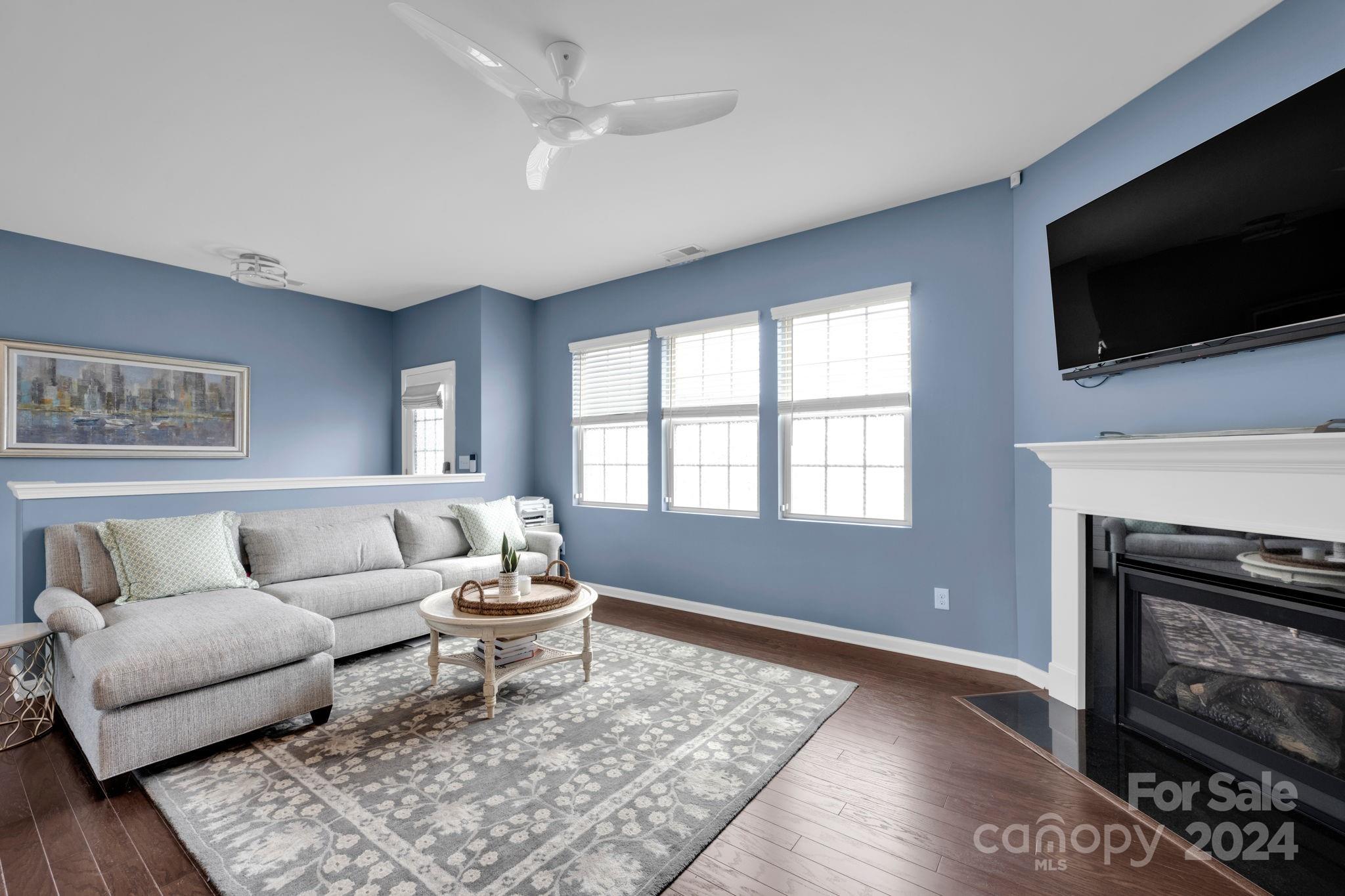 12834 Robert Walker Drive Davidson, NC 28036 - Photo 4 of 27 a living room with a fireplace and a flat screen tv