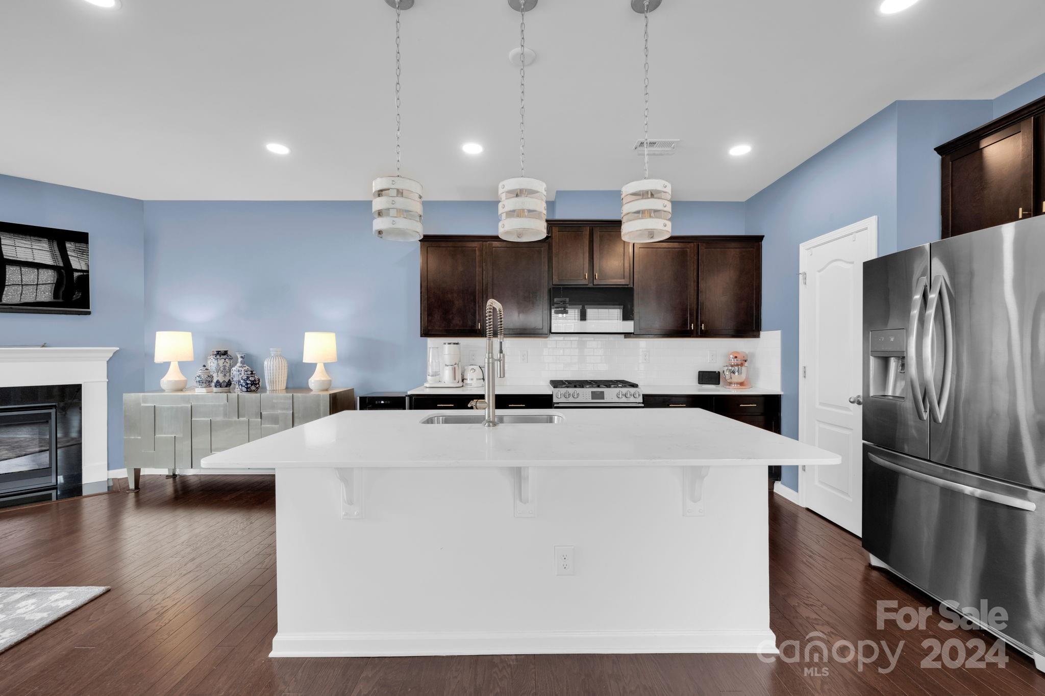 12834 Robert Walker Drive Davidson, NC 28036 - Photo 7 of 27 a large kitchen with cabinets a sink a counter and stainless steel appliances