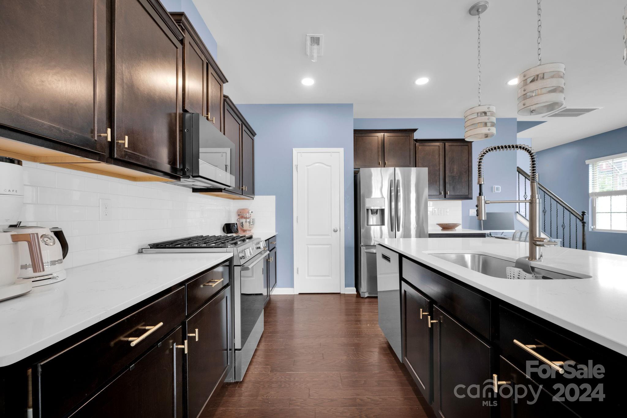 12834 Robert Walker Drive Davidson, NC 28036 - Photo 8 of 27 a kitchen with stainless steel appliances granite countertop a sink a stove and a refrigerator