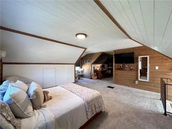 a bedroom with a large bed tv and a couch