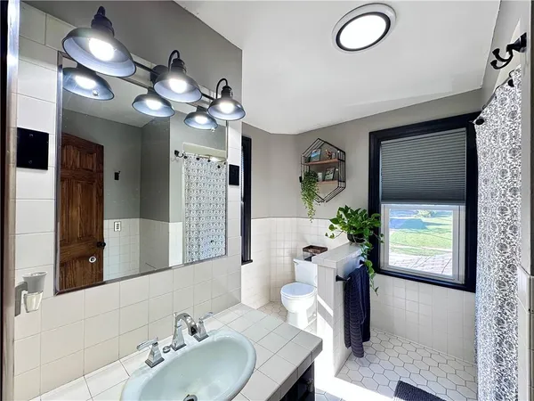 a bathroom with a sink a large mirror and a toilet