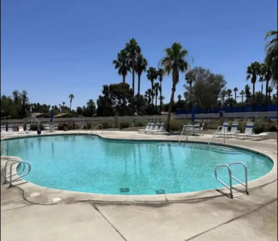 a swimming pool with outdoor seating and yard