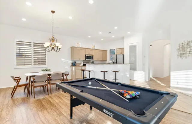 a living room with furniture a dining table and chairs with wooden floor