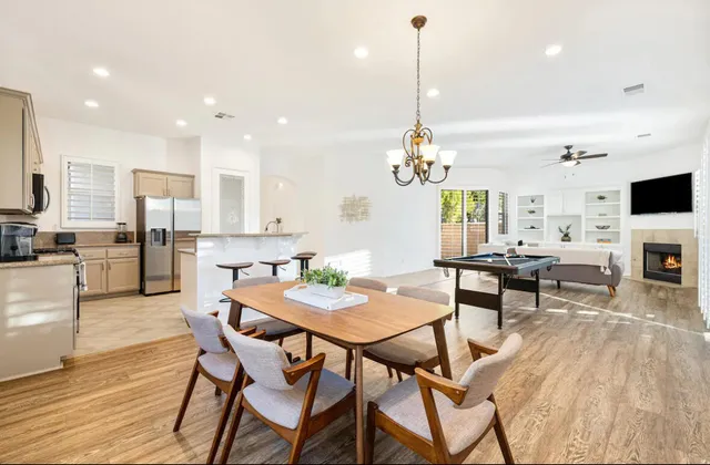 a view of a dining room and livingroom with furniture wooden floor a chandelier