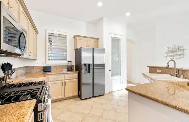 a kitchen with a sink a refrigerator and a stove top oven