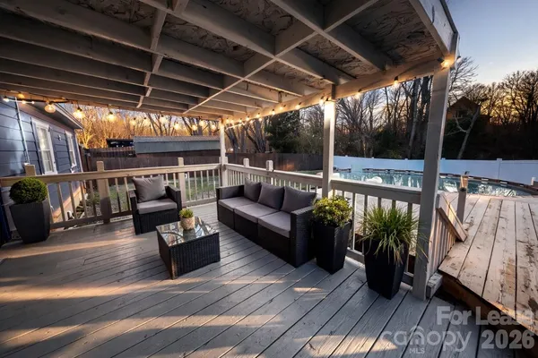 a view of roof deck with couches with wooden floor and fence