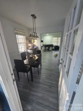 a dining room with furniture a chandelier and wooden floor