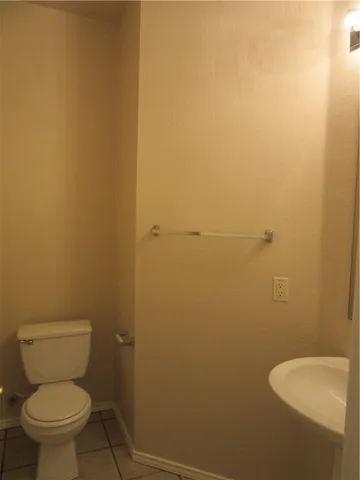 a white toilet sitting next to a white wall