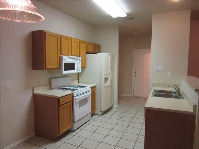a kitchen with a stove a refrigerator and a sink